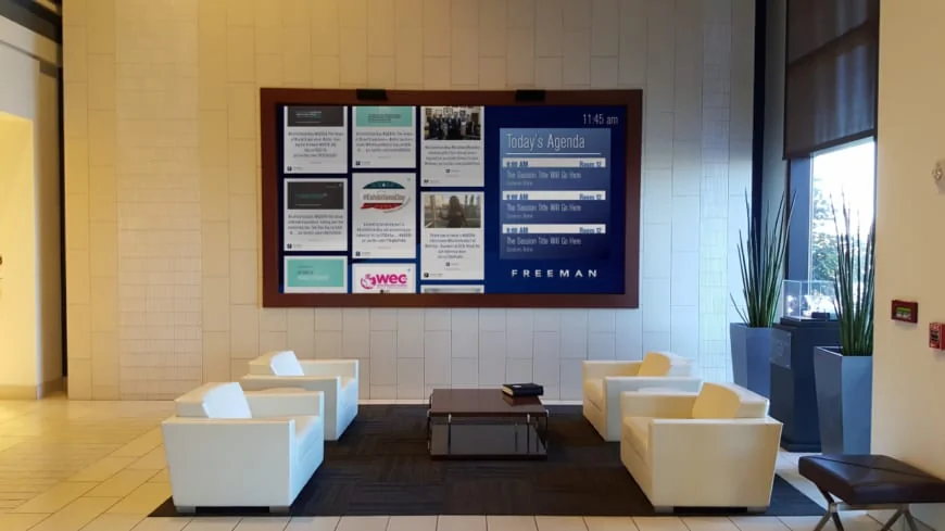 Digital signage screen in hotel lobby showing meeting agenda and information bulletin