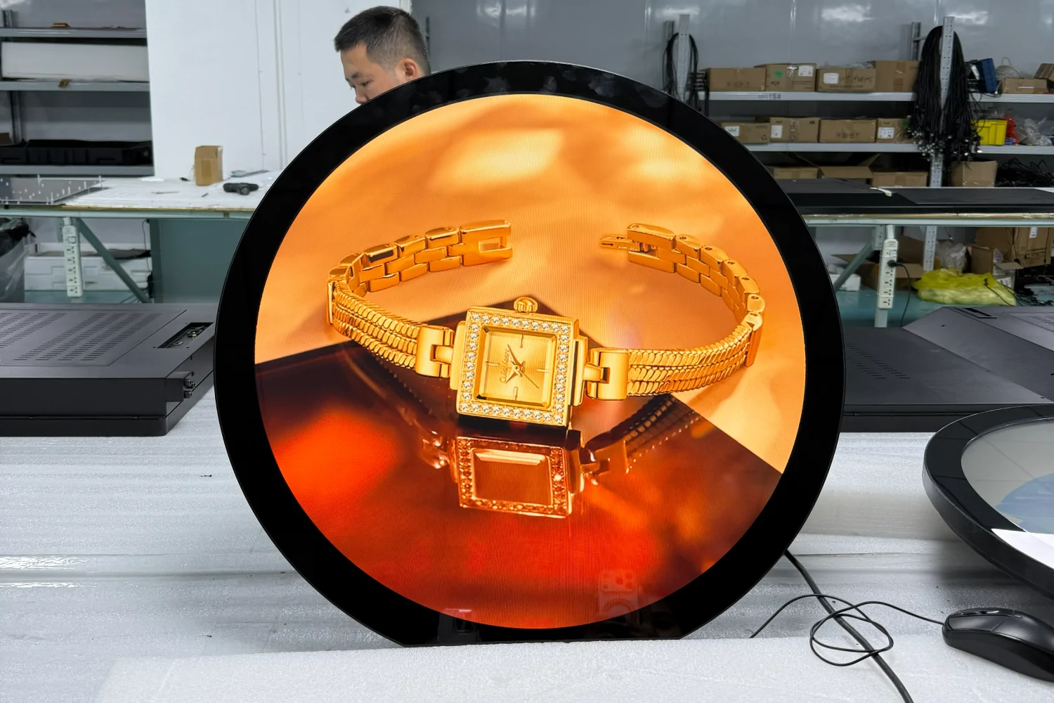 goxmart 23.6 inch circular lcd display, round digital signage demo with luxury watch image inside factory workshop