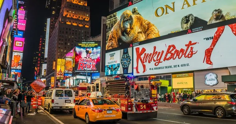 DOOH digital out of home advertising billboards in Times Square city street night scene