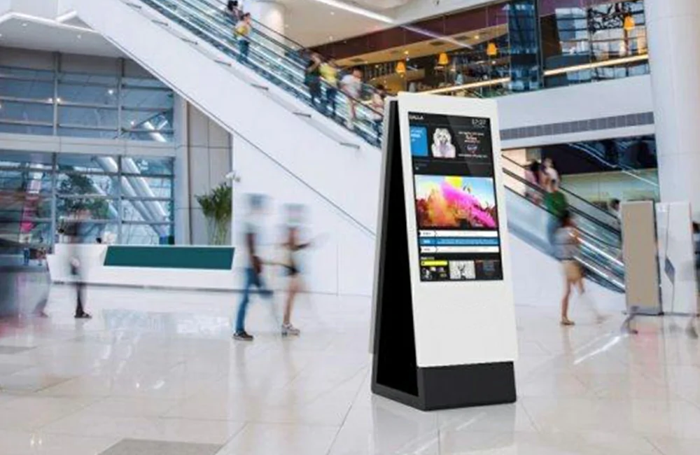 Dual-sided floor standing digital signage installed in shopping mall lobby near escalators for multi-side advertising
