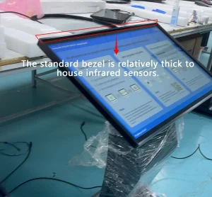 Factory photo of IR touch digital signage with thick bezel to house infrared sensors