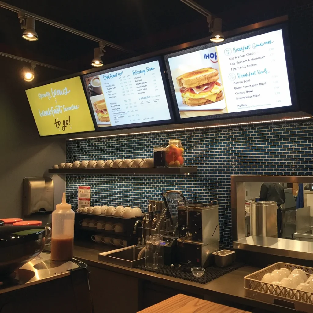 Digital menu board signage screens installed above restaurant counter